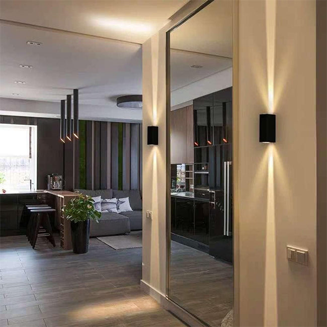 Contemporary hallway with black wall sconces and large mirror